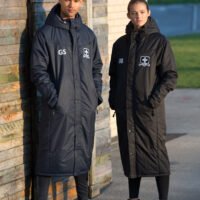 Ram Rugby Custom Stock Bench Coat in black with waterproof thermal fabric, zipped pockets, and heavy-duty two-way zip